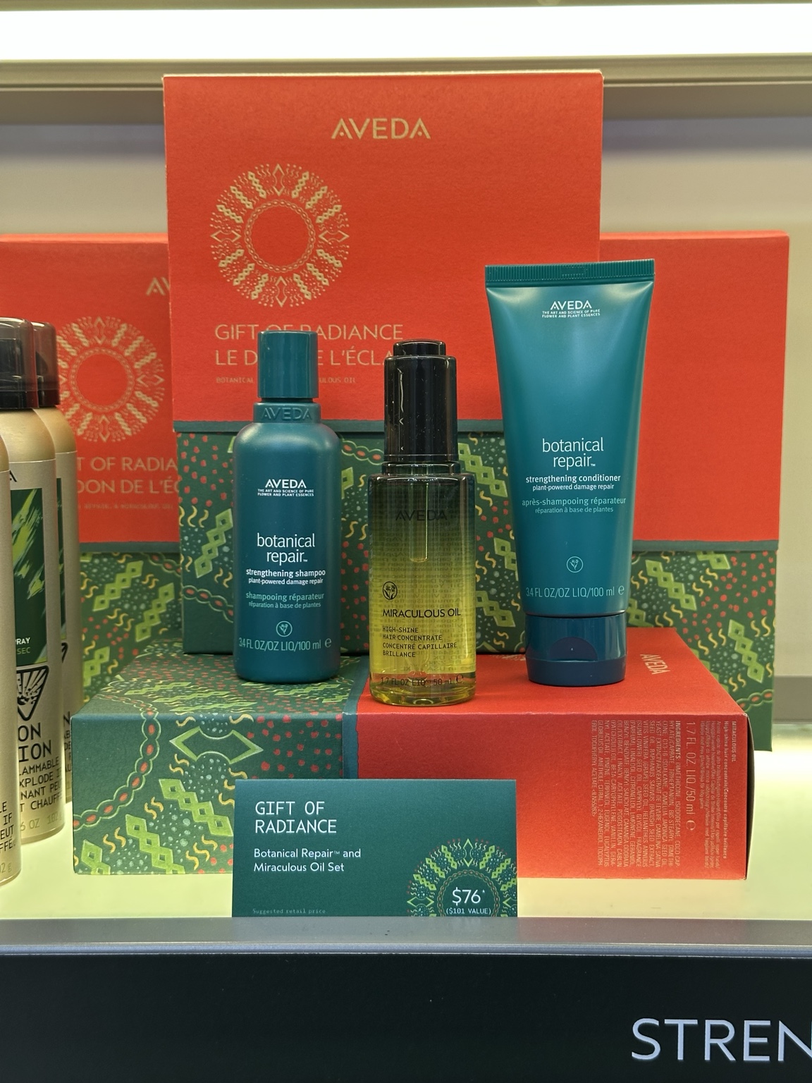 Aveda Gift of Radiance at ecoChic Victoria: Botanical Repair shampoo 100 ml, conditioner 100 ml and Miraculous Oil 50 ml, displayed with red and green gift boxes and a CA$76 price card.